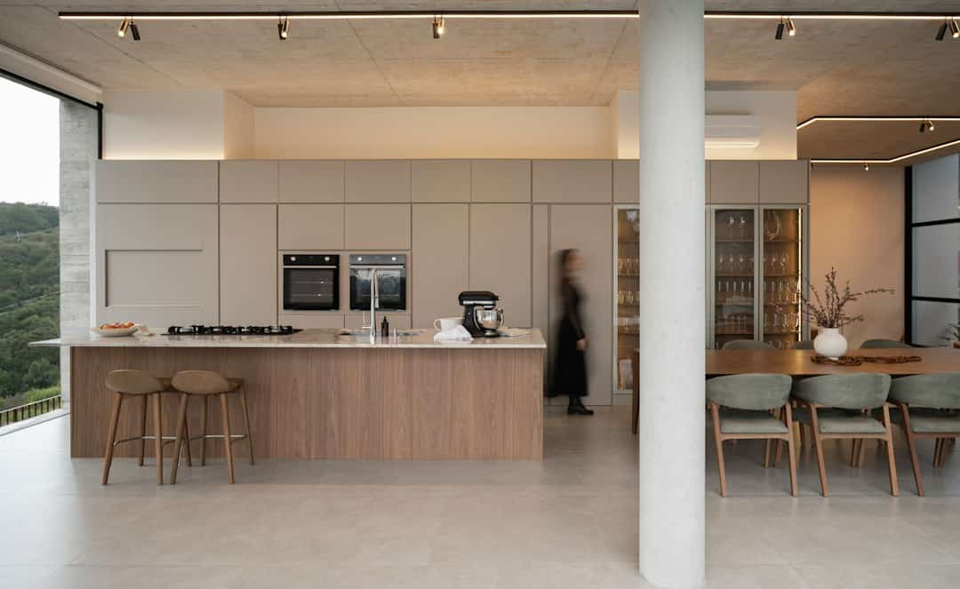 Contemporary kitchen island with wood accents and a continuous countertop, illustrating a minimalist kitchen layout