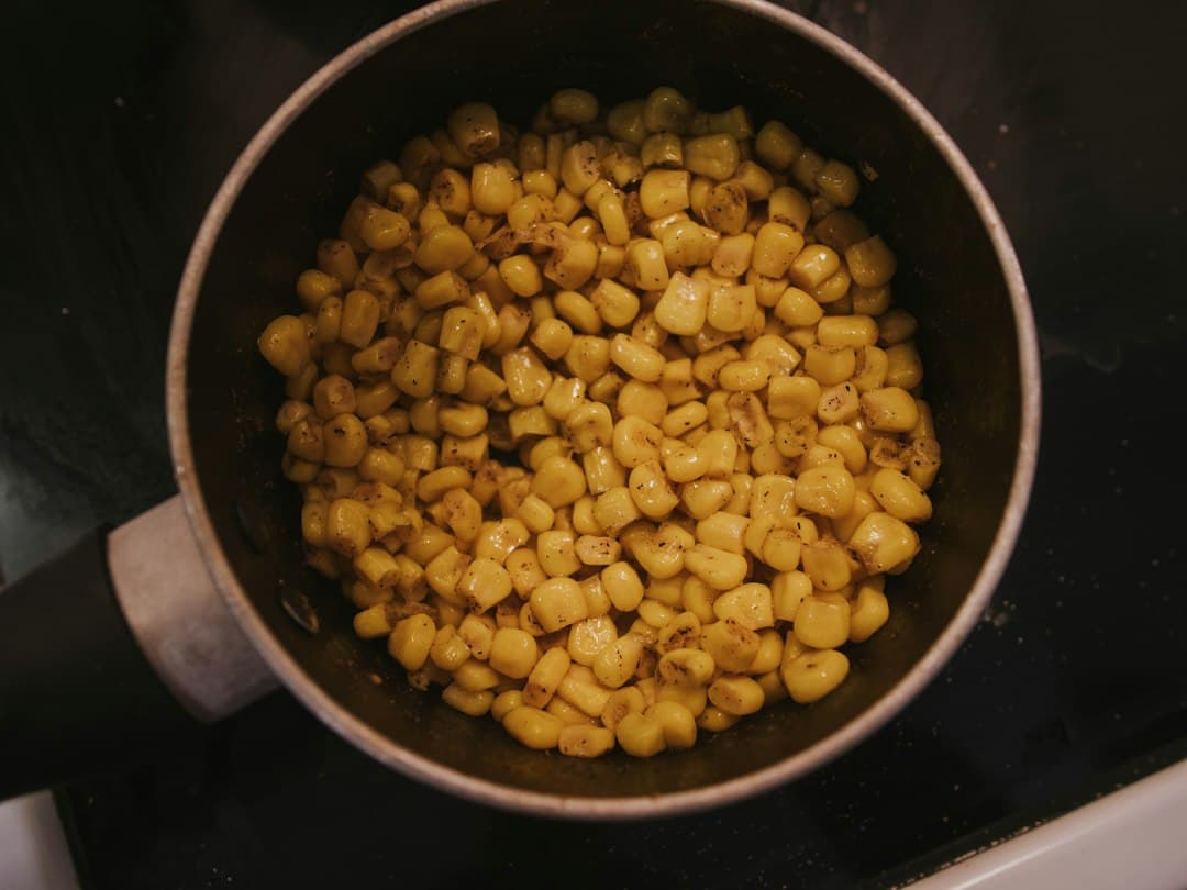 Pan of seasoned corn on a standard cooking surface, illustrating cookware rather than a hidden induction installation