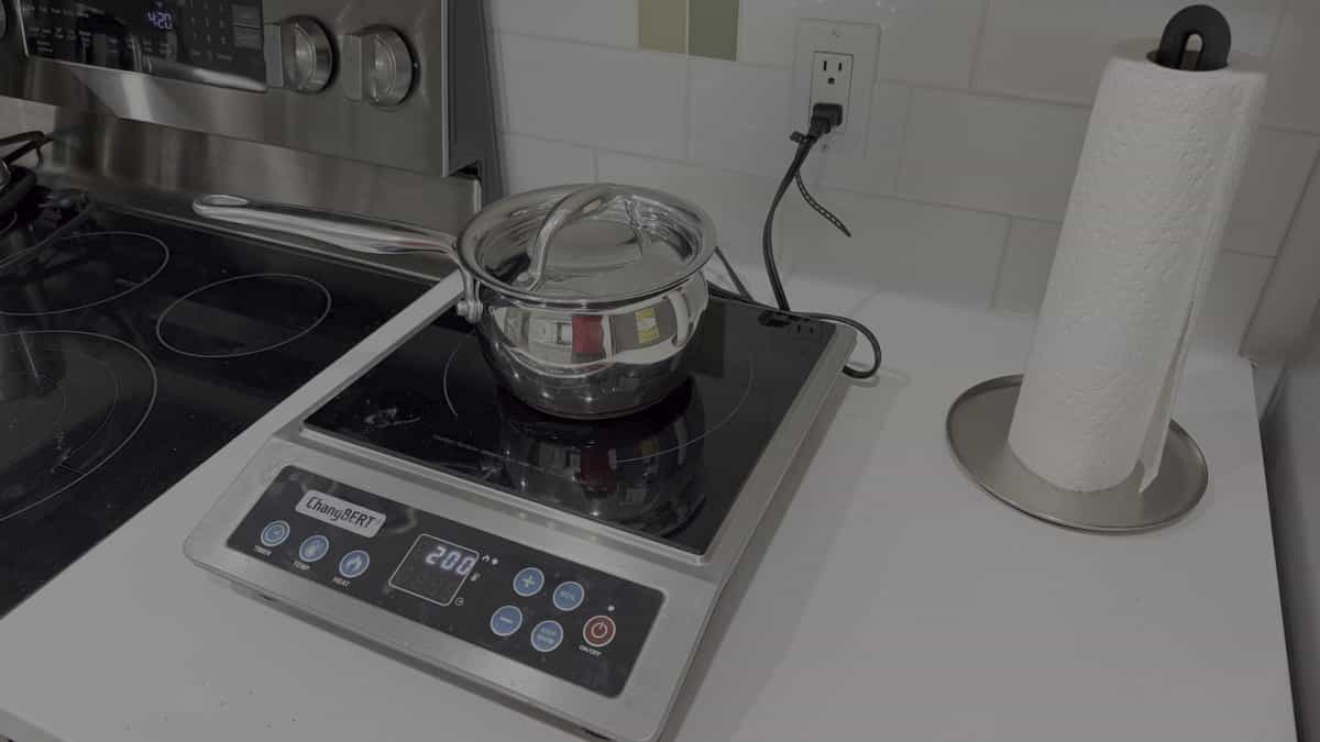 ChangBERT induction cooktop with a lidded stainless-steel saucepan on the kitchen counter